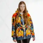 Jaka ar kapuci “Rebeka” ir sievišķīga un iedvesmojoša, tai ir koša tulpju motīva apdruka. Tā ir mūsdienīga izvēle, jo šis produkts apvieno sevī ilgtspējību un stilu. Jaka ir izgatavota no atkārtoti pārstrādāta poliestera un apdrukāts sublimācijas tehnikā. Jakas kapuce ir no dubulta auduma, bet pati jaka ir mīksta un patīkama. Jakai ar kapuci “Rebeka” ir unisex piegriezums ar pazeminātiem pleciem. Jaka ir lieliska izvēle sportiska stila cienītājām, jo ikdienā tā lieliski sader kopā ar džinsiem vai brīva stila biksēm. Arī tām dāmām, kuru ikdienas garderobē ir klasiska stila apģērbi, šī jaka ir laba izvēle aktīvai atpūtai vai pastaigām brīvajā laikā.
