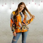 Krāsains džemperis “Ambertown” akcentēs Tavu māksliniecisko un neordināro personību, kā arī ļaus ikdienas apģērbam piešķirt īpašu noskaņu. Noslēpumaini abstrakti dzintara krāsas vecpilsētas silueti un viegli izplūdušas līnijas ļauj radīt savu stāstu par to – romantiska pastaiga pa vecpilsētas šaurajām ielām, pārdomu piesātinātā vienatnē vai sadotās rokās ar mīļoto? Esi savas dzīves mākslinieks un izpkrāso to pēc savas sirds patikas! Džemperis ir izgatavots no patīkama un izturīga materiāla, kam ir mīksta flīsa iekšpuse un gluda virspuse. To ir viegli kombinēt ar dažādām biksēm vai svārkiem. Džemperi ir pieejami plašā izmēru klāstā – no XS līdz 3XL.