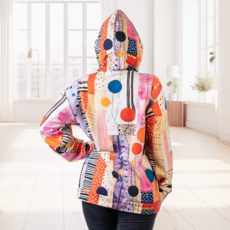 No mugurpuses patchwork stila krāsains hūdijs ar uzvilktu kapuci, modele demonsgtrē neitrālā vidē