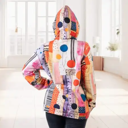 No mugurpuses patchwork stila krāsains hūdijs ar uzvilktu kapuci, modele demonsgtrē neitrālā vidē