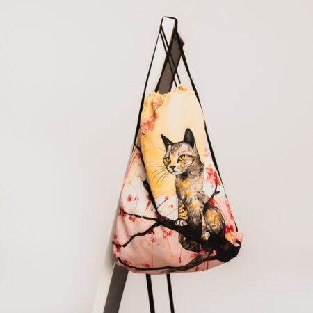 Aukliņsoma ar gaišu un priecīgu dizainu, kurā redzams reālistiski zīmēts kaķis