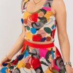 Krāsains un ērts sieviešu sporta tops "Forte" ar spilgtiem, abstraktiem rakstiem. Attēlā redzama modeļa valkāts īsais tops un pieskaņoti svārki.