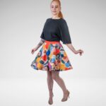 Saules piegriezuma svārki, kuru dizainu veido krāsaini abstrakti laukumi un sirds formas elementi, kas savijas ar līnijām un punktiem. Attēlā redzams svārku kuplums