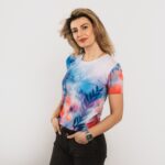 sieviete ģērbta zilu un rozā toņu t-kreklā, dizainā ziedu motīvs