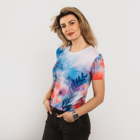 sieviete ģērbta zilu un rozā toņu t-kreklā, dizainā ziedu motīvs